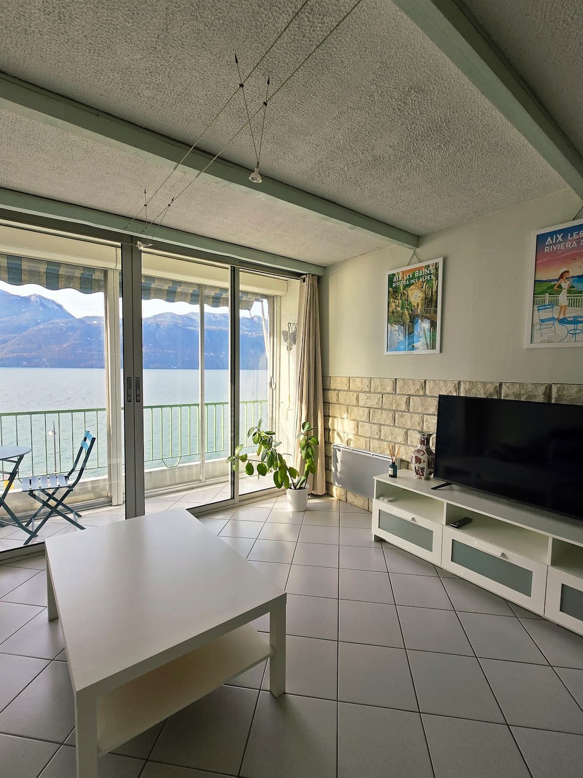 Séjour et télévision, balcon et lac en fond