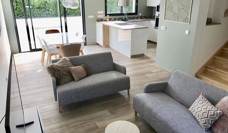 Séjour avec deux canapés, ouvert sur la salle à manger et la cuisine